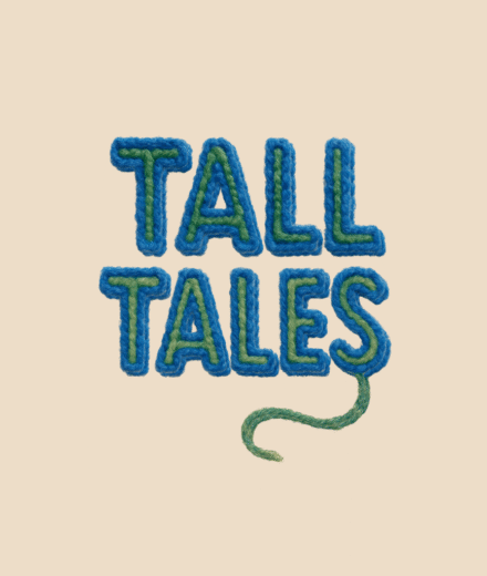 Embroidered words 'Tall Tales' stitched in blue and green yarn on a soft, light tan fabric background. The chunky, wooly letters are stacked and centered, with a loose green thread playfully curling away from the final letter, evoking a handmade, storybook feel.